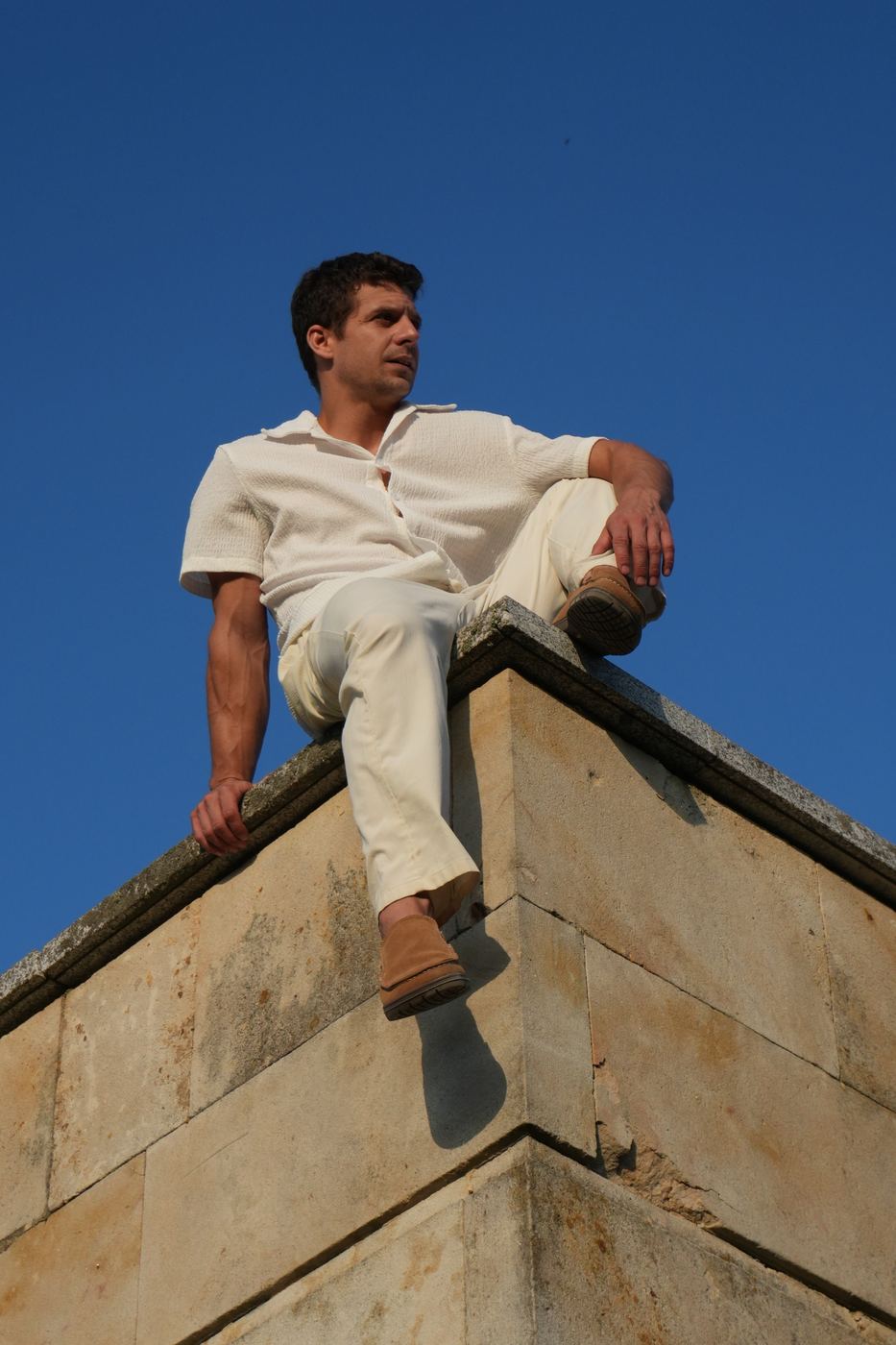 Seated on the wall edge